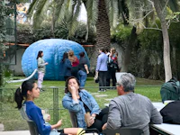 a group of people sitting around a table in a garden